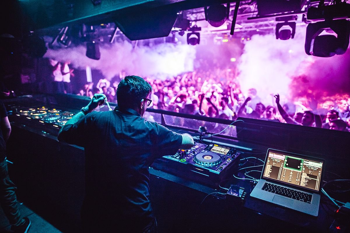 Photo of a DJ playing in front of a packed dance floor