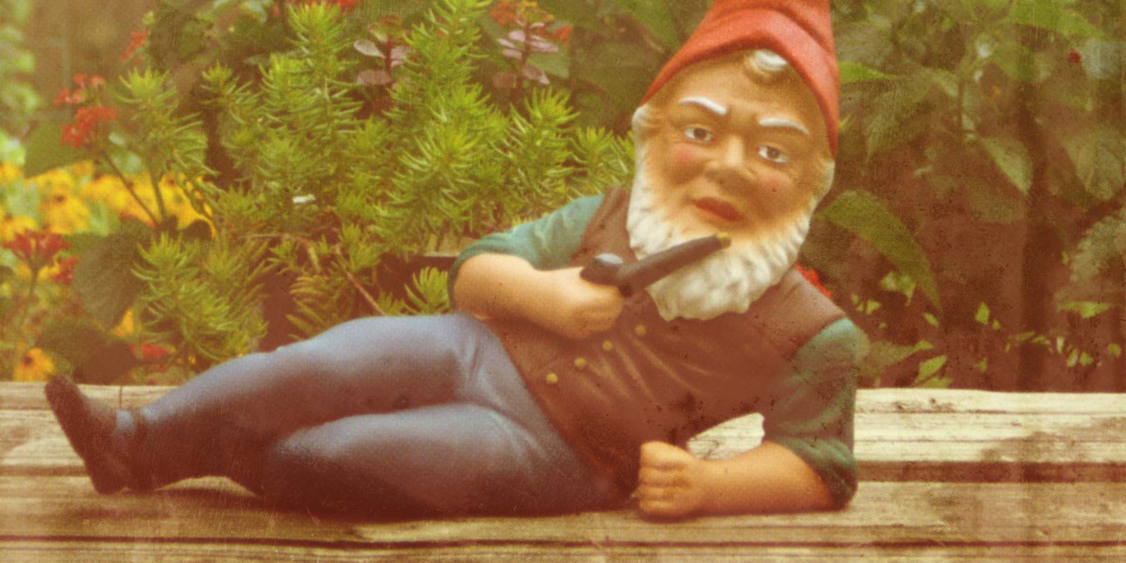 Statue of a reclining garden gnome smoking a pipe