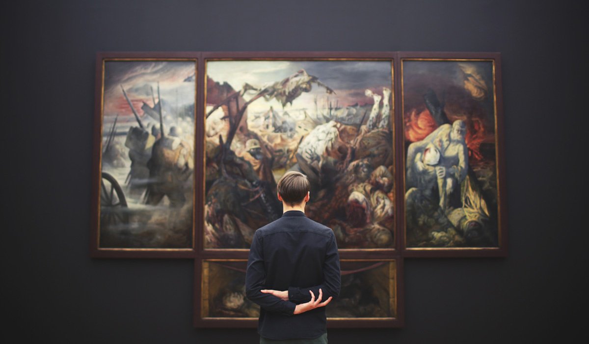 Man looking at an artwork hanging on a gallery wall